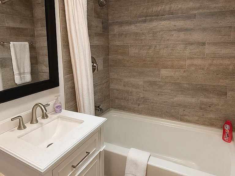 Stylish shared bathroom with shower/tub combo and separate vanity area.