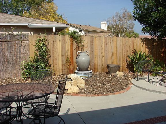 cozy backyard with fire pit and fountain.