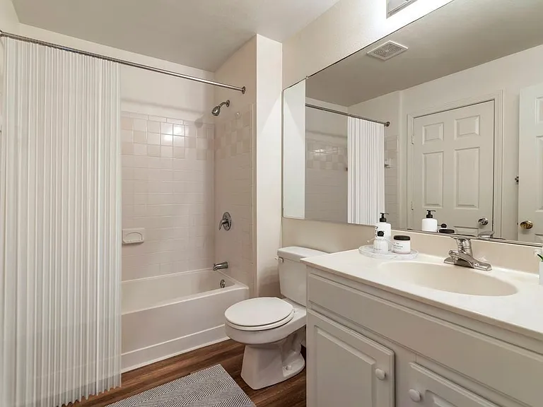 Renovated Package II bath with white cabinetry, white granite countertops, and hard surface plank flooring