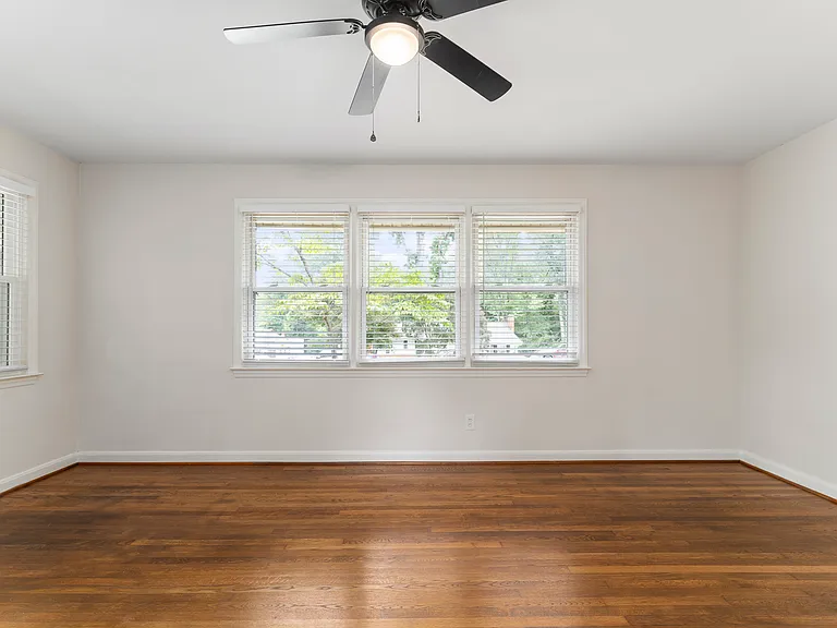 Large living room offers abundant light and opens to kitchen.