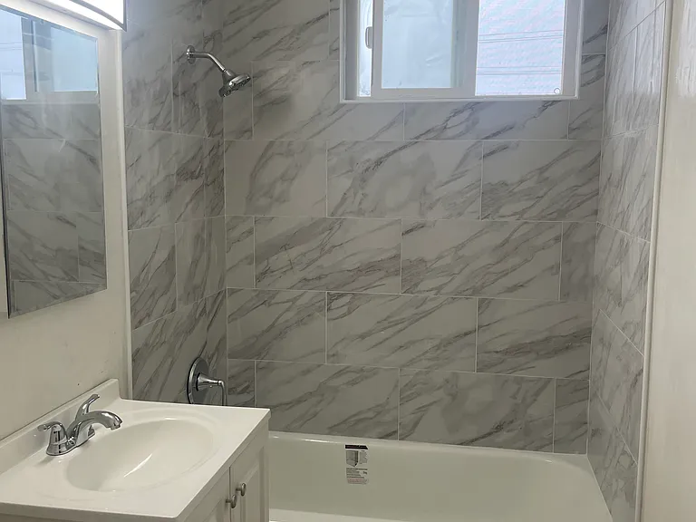 New bathtub and shower head with new tile