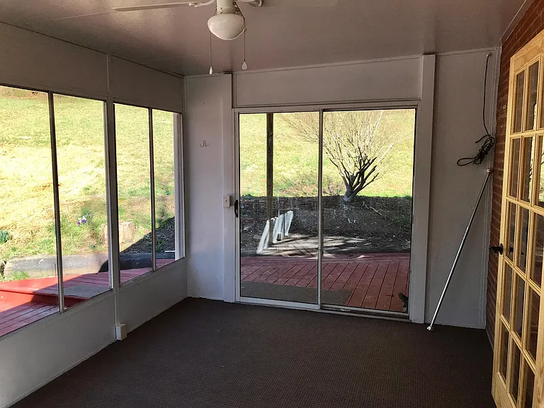 Sunroom, shown is sliding glass door at far side. Kitchen entrance on right.