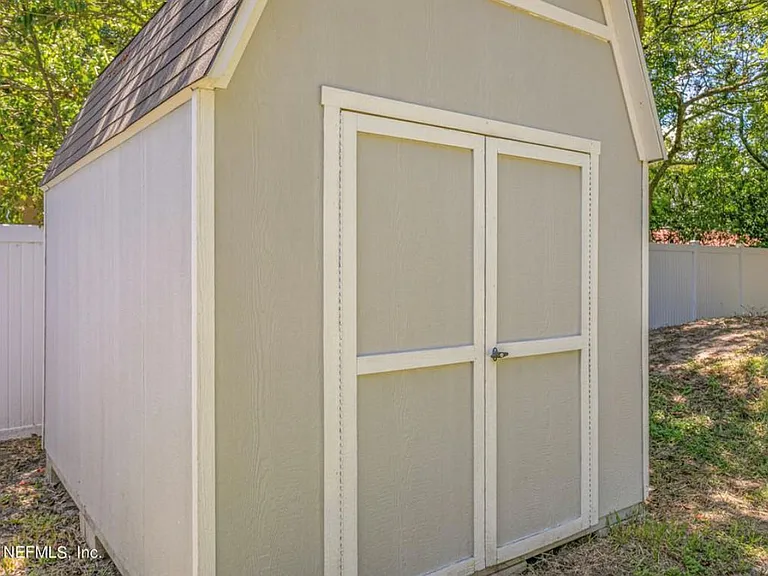 Fenced back yard with storage shed.