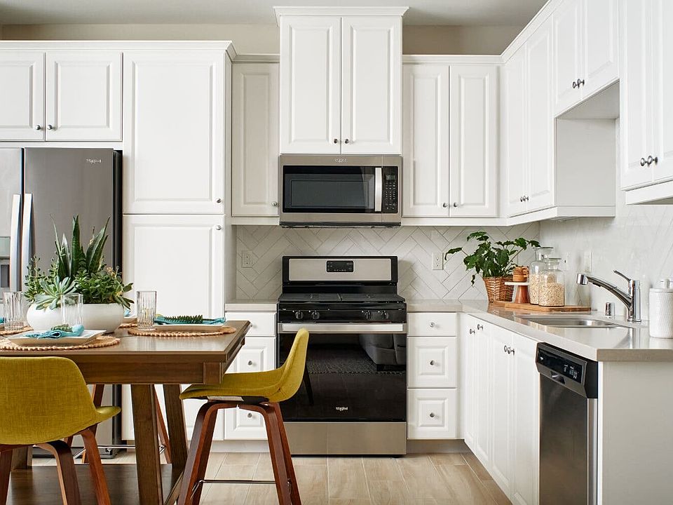 White Kitchen with dining table island in Residence 1 at Indigo at Canvas Park