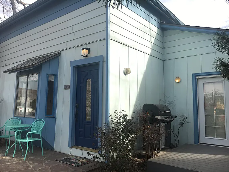 The blue door in the left of this photo leads to the upstairs unit. The french doors at the deck on the right of the photo lead to the kitchen. Grill included.