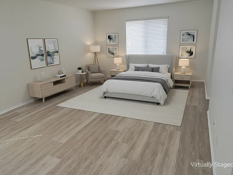 Primary bedroom, with entrance to en-suite bathroom on the right, virtually staged