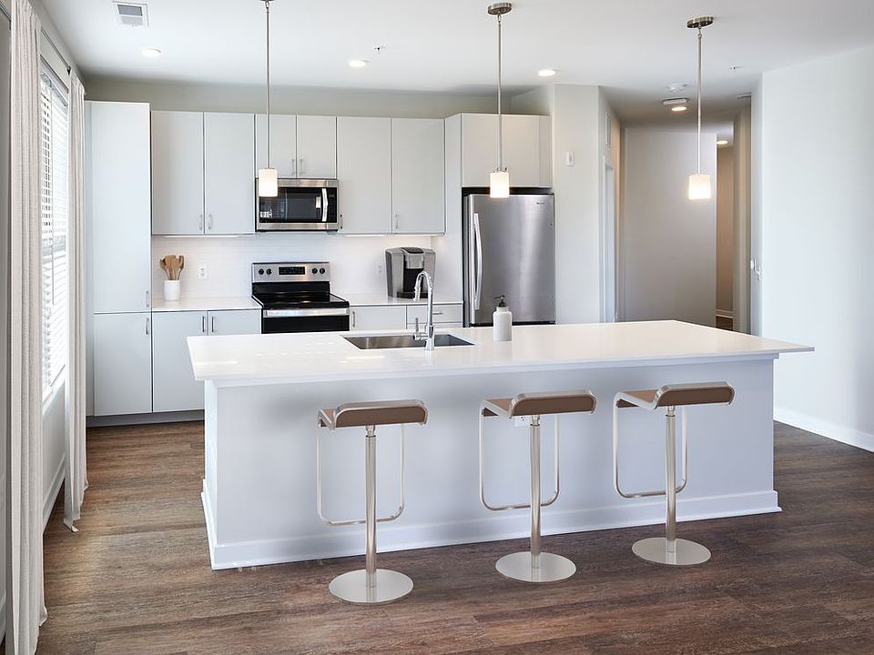 Modern kitchens with light grey cabinetry, white quartz countertops, stainless steel appliances, and hard surface flooring (Representative photo)