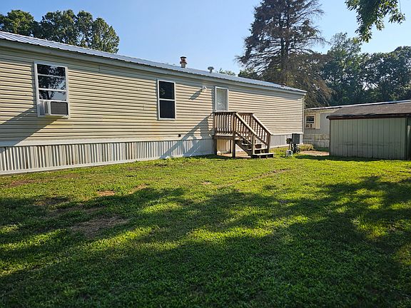 Exterior of home (backside). Home has brand new metal roof. Shed for additional storage.