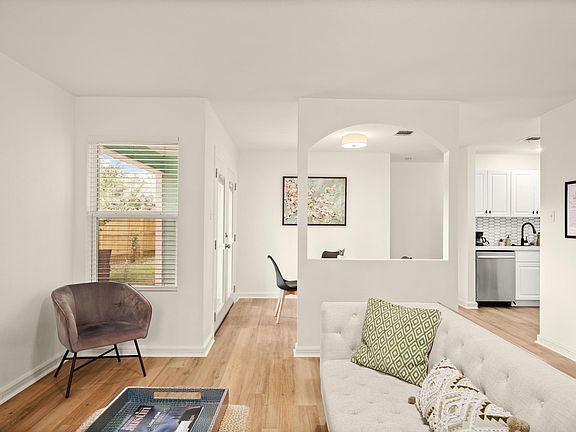 living room with view of side door to backyard and dining room