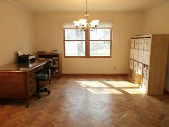 Crown molding and a herringbone patterned hardwood flooring, highlight this dining room.