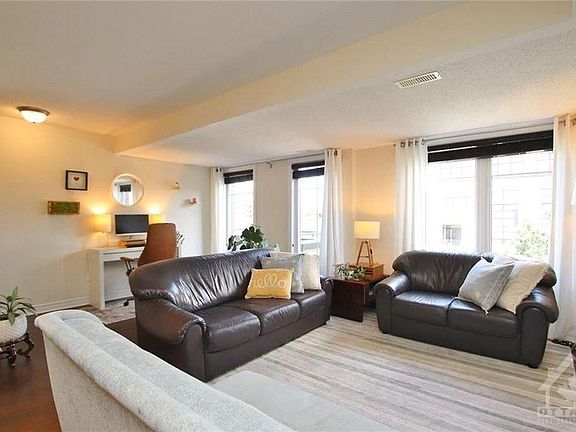 3 full size windows bringing ample light in living area accompanied with a office desk