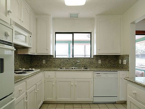 Close up of kitchen-updated with granite counters, stove top and oven
