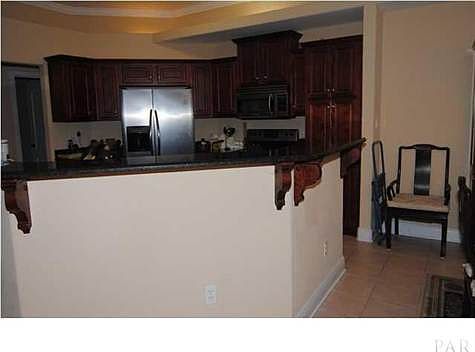 Kitchen with cherry-stained cabinets, stainless steel applia