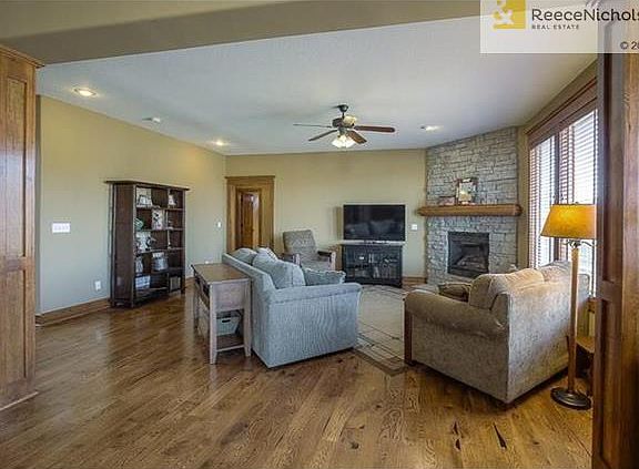 Spacious family room with stacked stone fireplace and hardwood floors