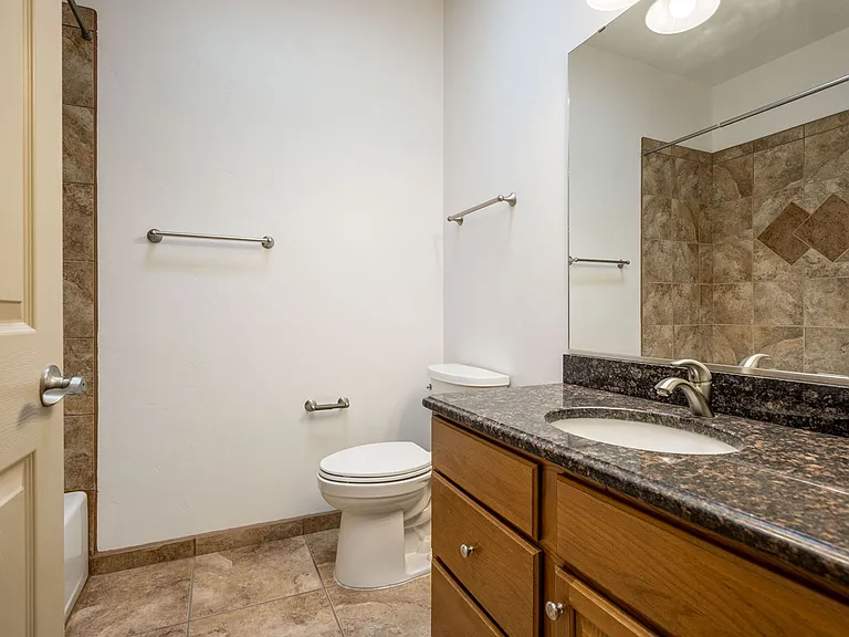 Guest bathroom with shower/tub combo & skylight. Linen closet & coat closet.