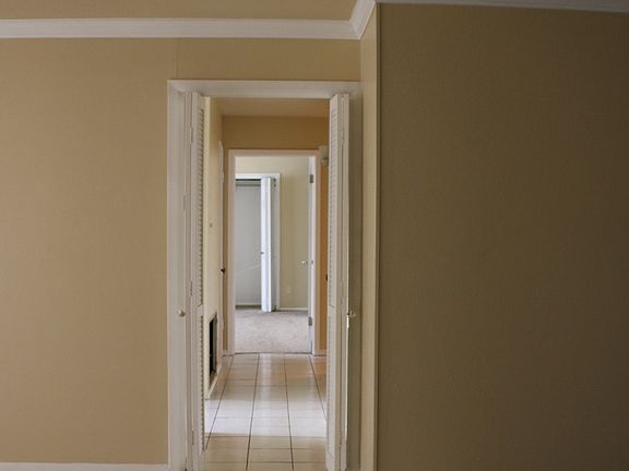hallway leading to kitchen and 3 bedrooms