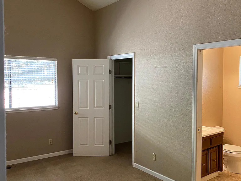 Primary bedroom with vaulted ceilings and full bath and walk in closet