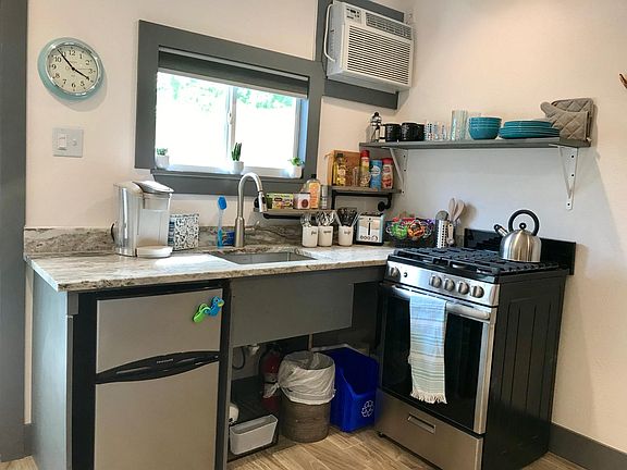 Kitchen with stove, mini fridge, microwave and Keurig