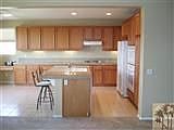 Granite countered kitchen with much storage.