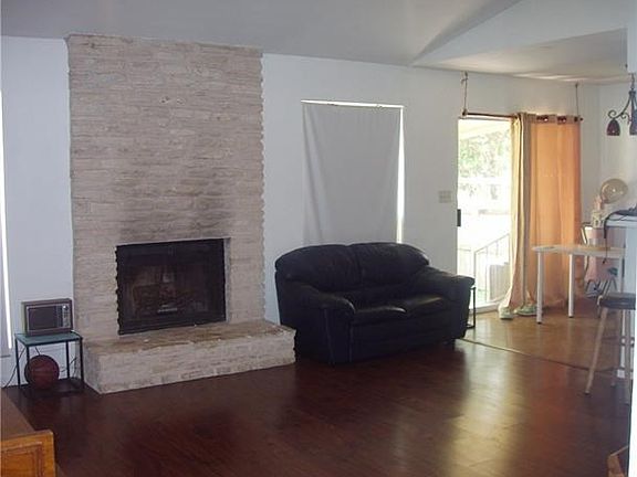 Laminate type flooring in living arez with fireplace and high ceilings.