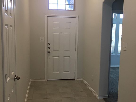 Dramatic entryway, with two light fixtures, transom window, coat closet, and gorgeous premium tile.