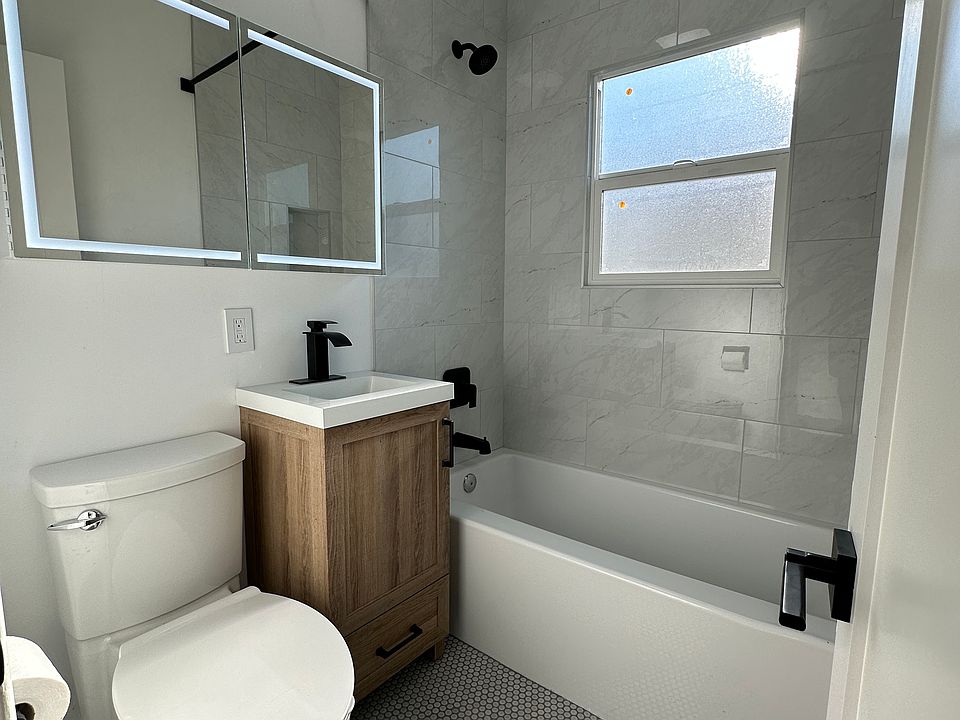 Fully remodeled bathroom with vanity mirror storage.