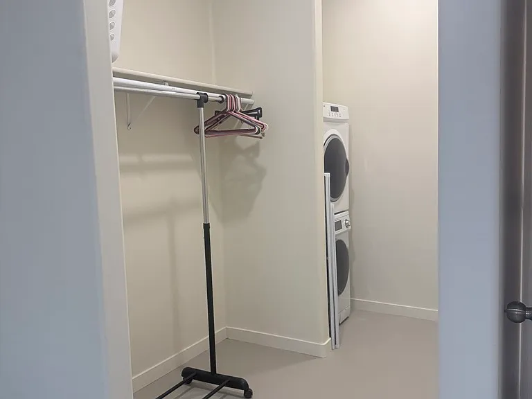 Bedroom closet with washer/dryer.