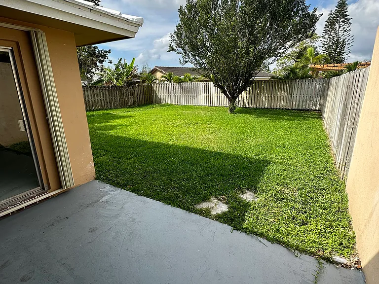 Backyard. Sliding door in master bedroom and living area that leads to backyard.