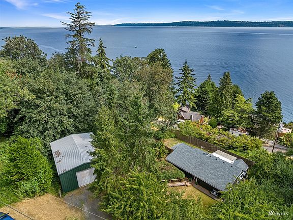 A great aerial view of the 1,200 square-foot shop, the roofline of the home (check out the new roof), the shipping lane along the east passage and in the distance - the Fauntleroy Ferry Dock.>