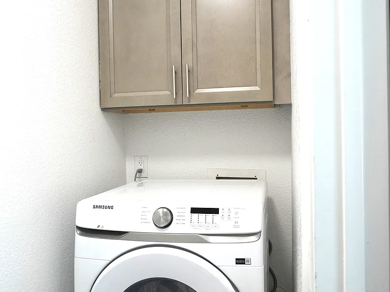 Washer in small laundry room between kithchen and garage.