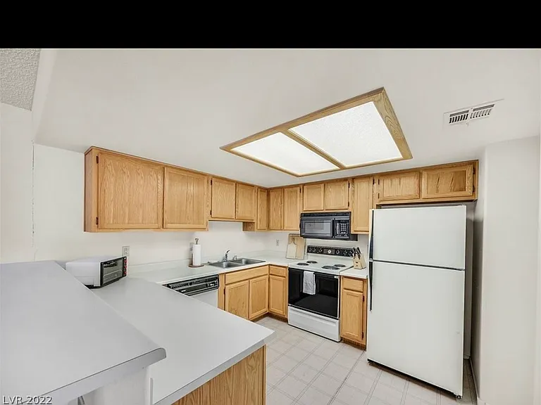 Kitchen equipped with Electric stove top and oven, Refrigerator, and microwave.