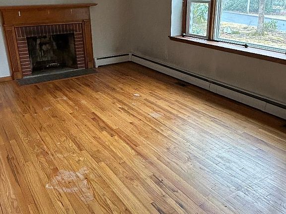 Very spacious living room with clean working fireplace and sunlight