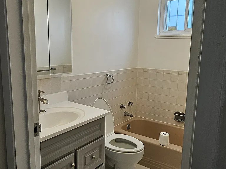 Bathroom with new vanity, mirror, lights, paint, and ventilation fan.