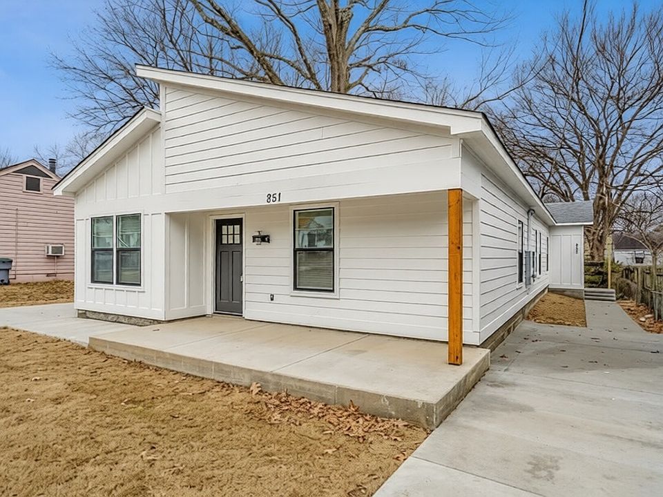 A crisp, modern bungalow featuring bold asymmetrical lines and a striking white board-and-batten facade.