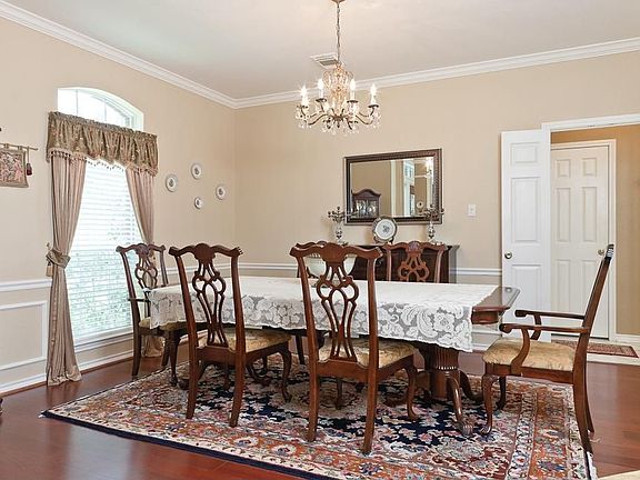 The dining room has hardwood floors, chandelier, crown moulding and double doors leading to the kitchen.