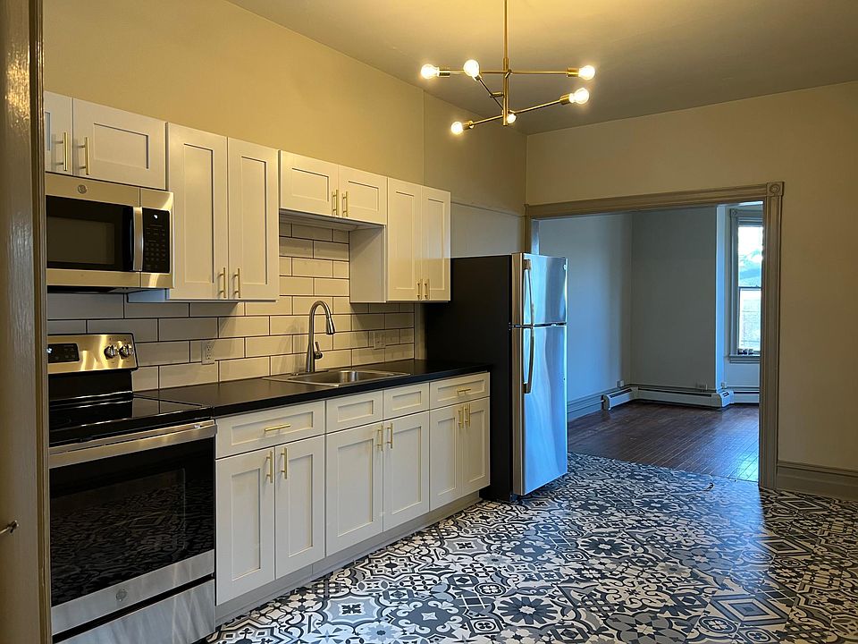 Large eat-in kitchen with updated cabinets, stainless steel appliances, tile backsplash, and high-end finishes