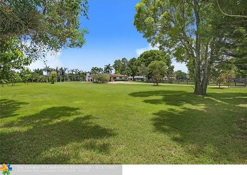 View from the north corner of the over 3 acre lot towards the home.  This property has plenty of Mango trees but also room to build, grow more trees or expand your grazing grounds.