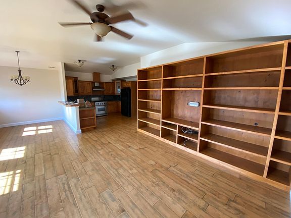 Great room with built-in shelving, looking into kitchen/dining