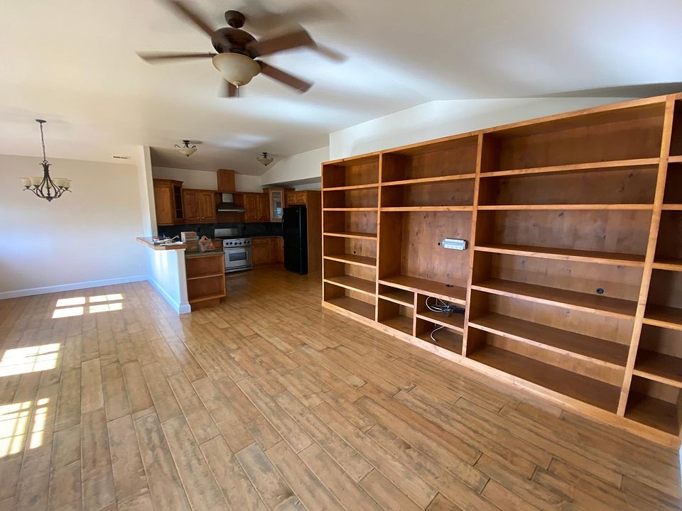 Great room with built-in shelving, looking into kitchen/dining