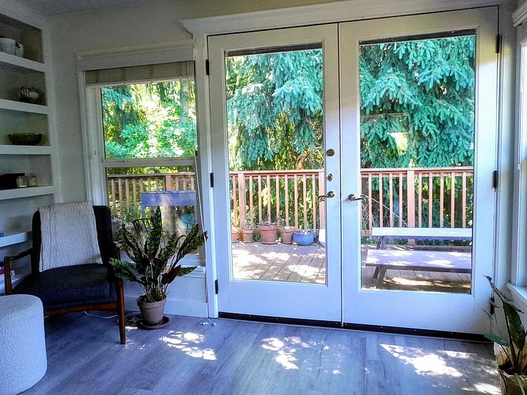 View from family room of built in book case and french doors onto private deck.