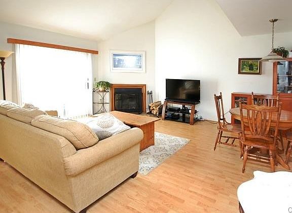 Light and open vaulted living room w/fireplace and private deck