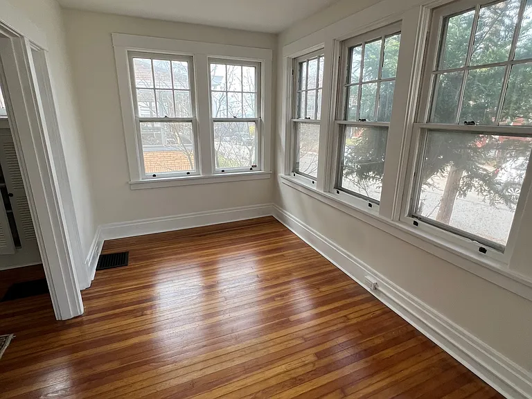 Beautiful sun room with refinished hardwood floor.