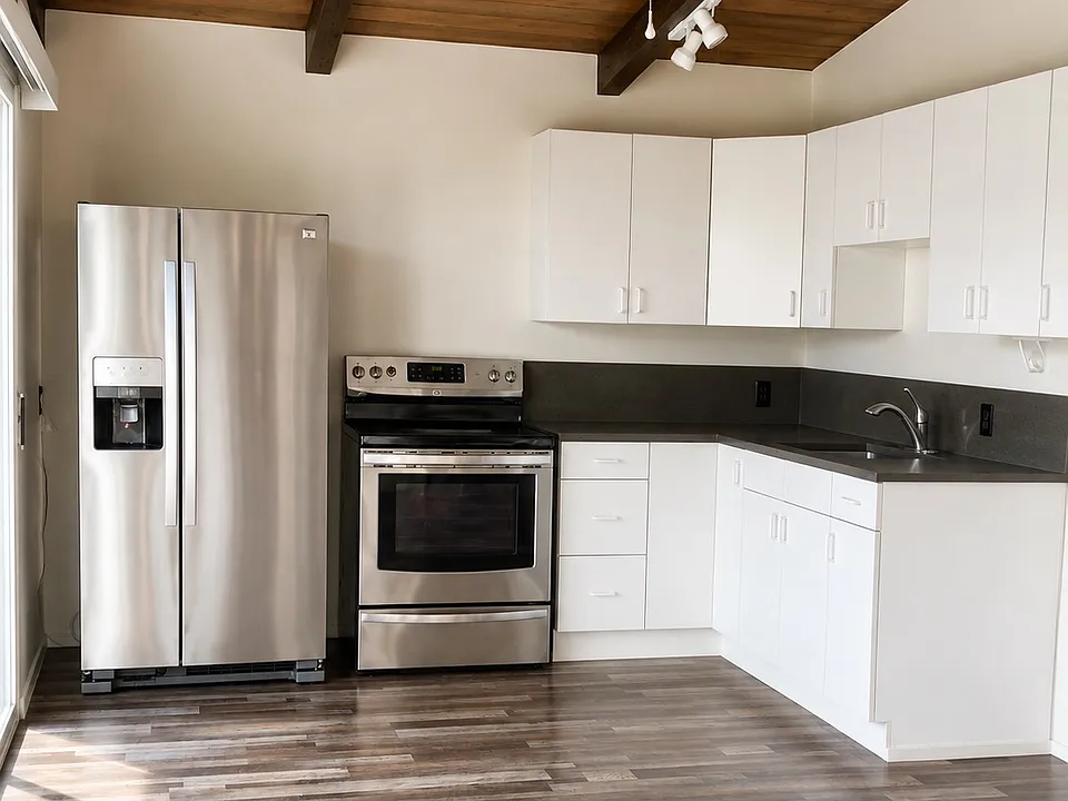 The kitchen has a stainless steel refrigerator w/ice maker, range, quartz countertop, a stainless steel sink