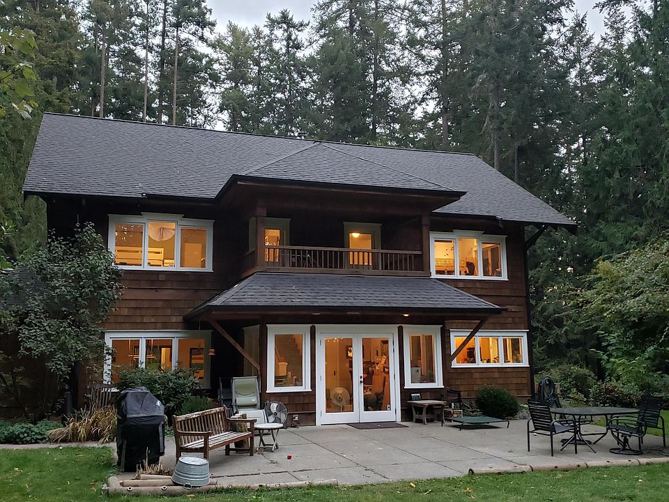 Grand cedar sided, trimmed out windows. This view is looking at house from the backyard/soccer field area. Note balcony on 2nd floor adjoining the two south facing bedrooms. Double doors on 1st floor open to cement patio, BBQ, outdoor entertaining area