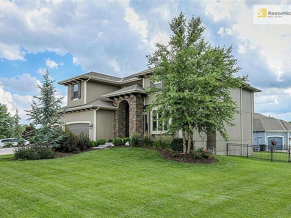 This gem sits on a large corner cul-de-sac lot with extensive landscaping and an iron fence.