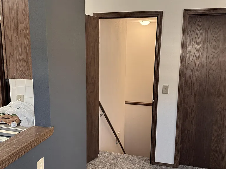 From dining area, showing kitchen pass through and stairs leading to basement.