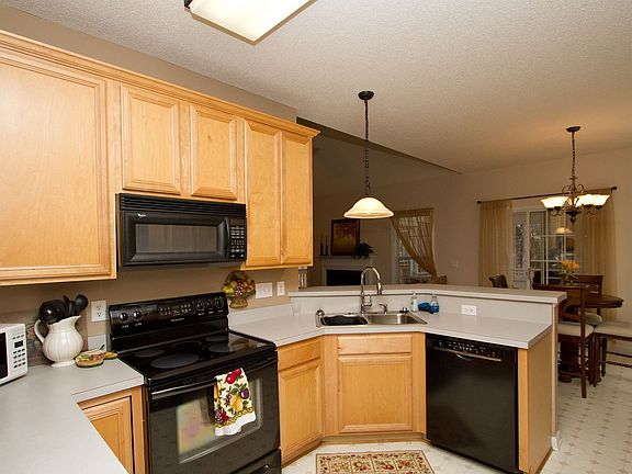 Warm neutral colors, black appliances & ample cabinets create a great space.