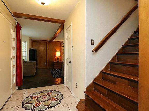 Lovely wood stairway graces the warm and inviting entry. Tile flooring leads you to the family room 