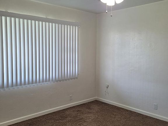 Master bedroom with large window to front yard and ceiling fan.
