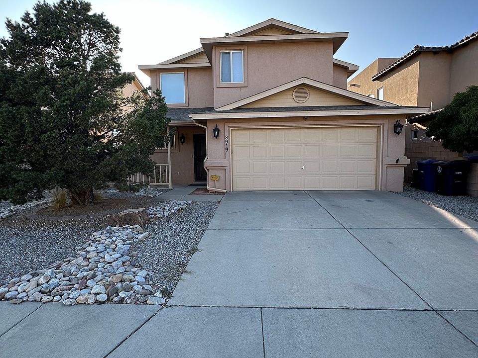Front view facing east toward the Sandia Mountains. Room for two vehicles in the driveway and two in the garage.